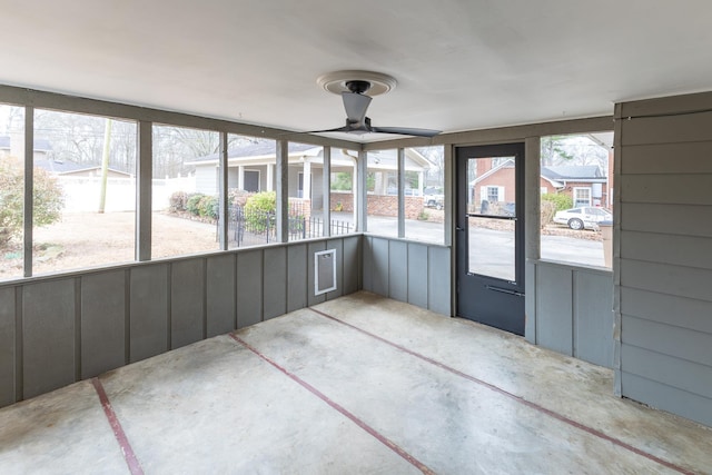 unfurnished sunroom featuring a ceiling fan