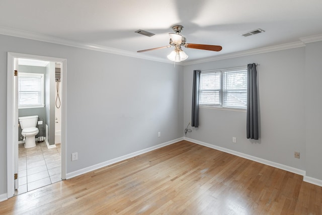 unfurnished bedroom with light wood-style floors, visible vents, crown molding, and baseboards