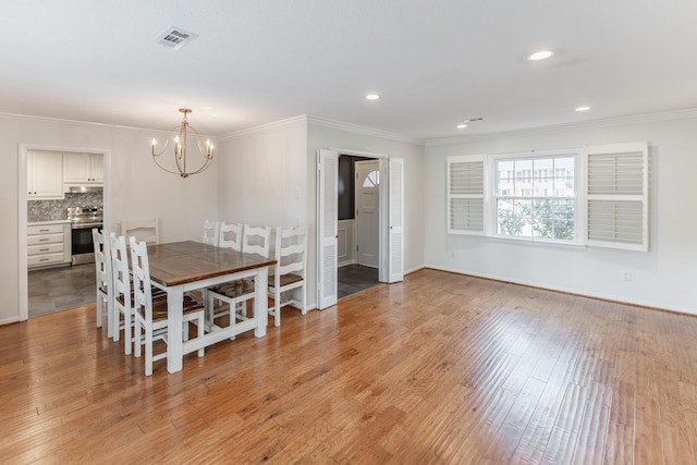 dining space featuring a notable chandelier, recessed lighting, visible vents, light wood-style floors, and ornamental molding