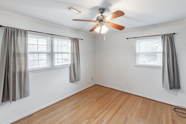 spare room featuring light wood-style floors, baseboards, and ornamental molding