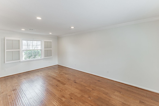 unfurnished room featuring crown molding, baseboards, and wood finished floors