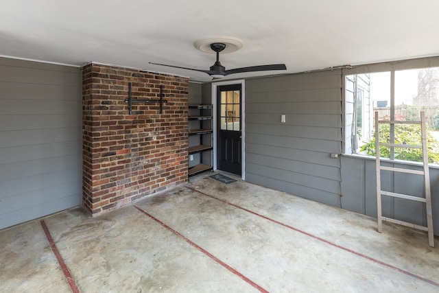 property entrance with brick siding, a ceiling fan, and a patio