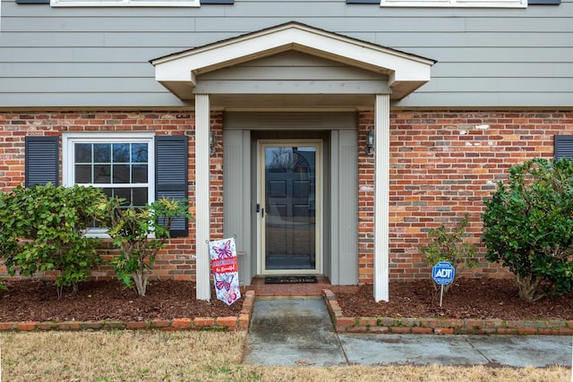 view of exterior entry with brick siding