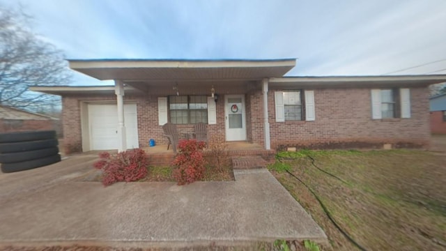 view of front of house with a garage, covered porch, and a front lawn