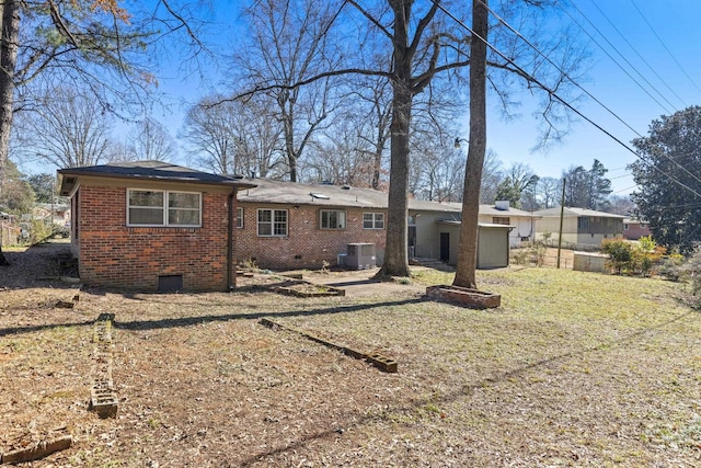 rear view of property with central AC unit and a lawn