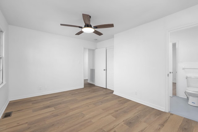 unfurnished bedroom with connected bathroom, light hardwood / wood-style flooring, and ceiling fan