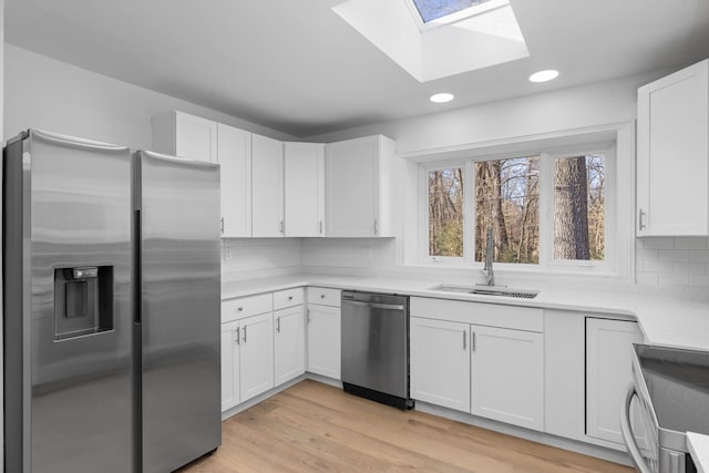 kitchen with white cabinetry, sink, decorative backsplash, and appliances with stainless steel finishes