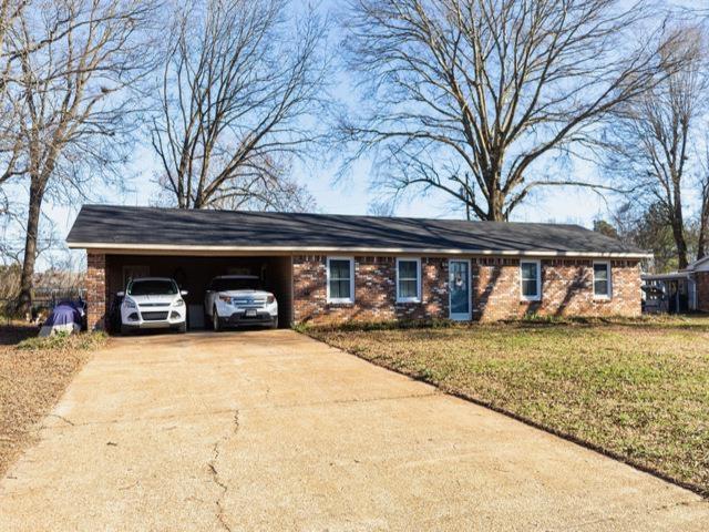 ranch-style home with a carport and a front yard