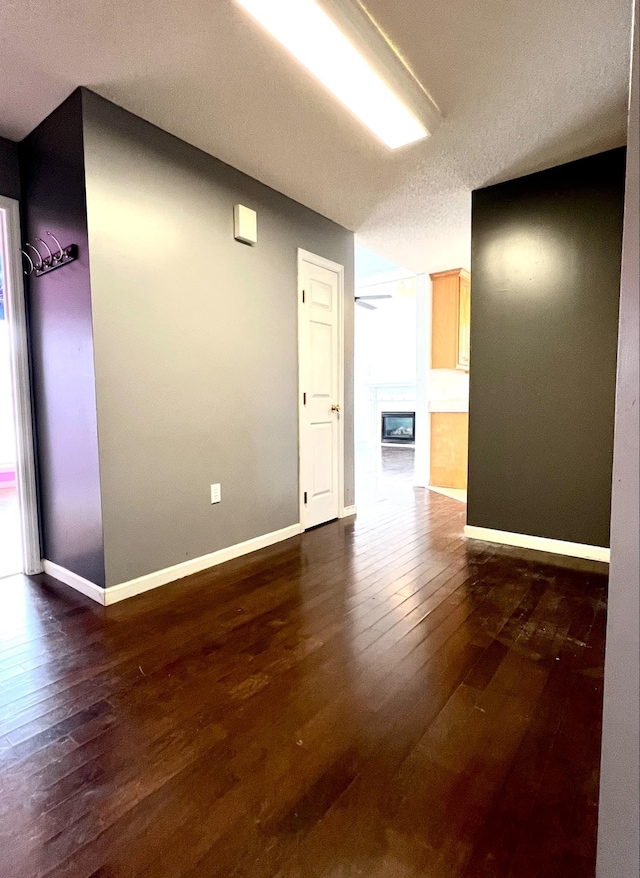 empty room featuring dark hardwood / wood-style flooring, a textured ceiling, and ceiling fan