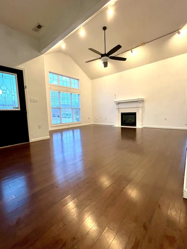 unfurnished living room with dark wood-type flooring, ceiling fan, and high vaulted ceiling