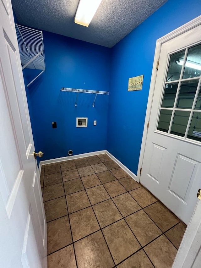 laundry room with hookup for a washing machine, electric dryer hookup, tile patterned flooring, and a textured ceiling