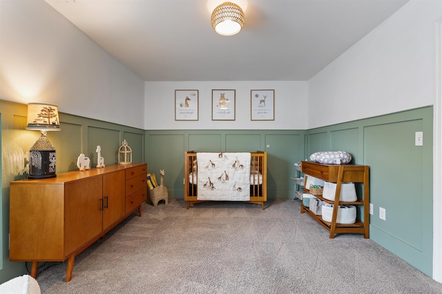 bedroom featuring light carpet and a decorative wall