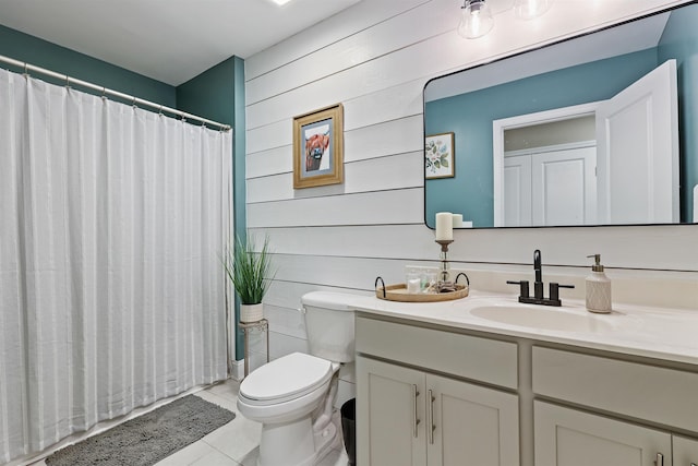 bathroom with a shower with shower curtain, toilet, wooden walls, vanity, and tile patterned flooring