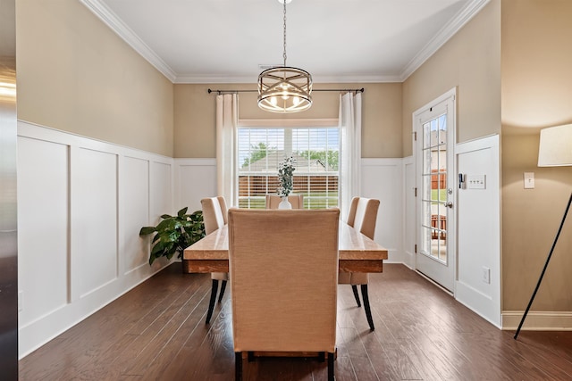 dining area featuring a chandelier, dark wood-type flooring, a decorative wall, and crown molding