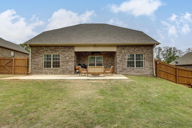 back of house with a patio area, brick siding, fence, and a lawn