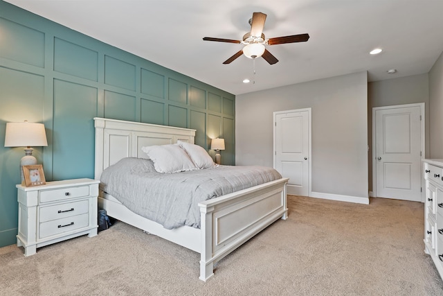 bedroom with light carpet, a decorative wall, a ceiling fan, and recessed lighting