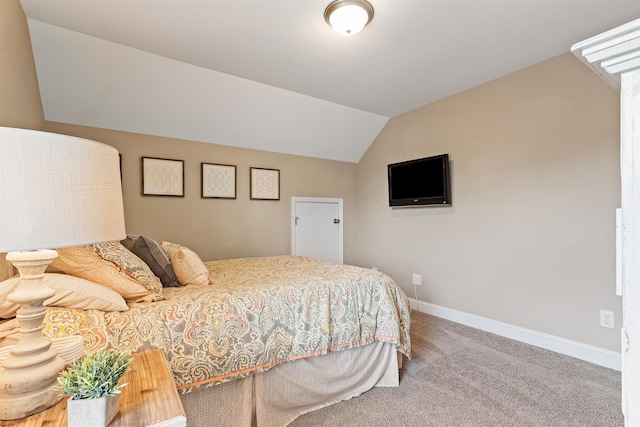 carpeted bedroom featuring baseboards and vaulted ceiling