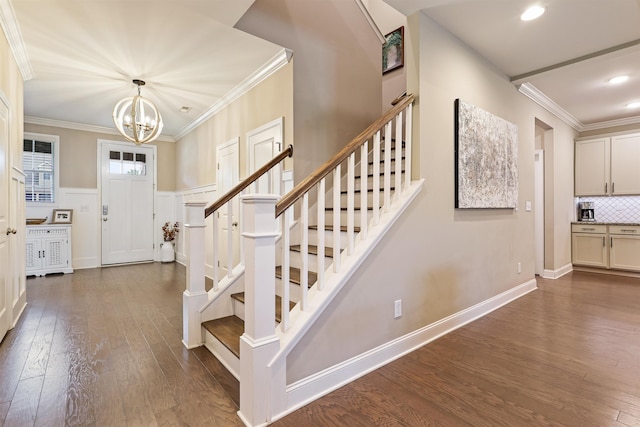 entrance foyer featuring stairs, ornamental molding, dark wood-style flooring, and wainscoting