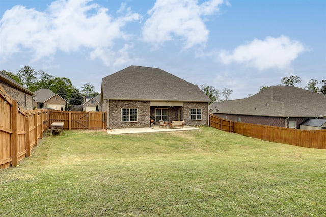 rear view of house featuring a patio area, a lawn, and a fenced backyard