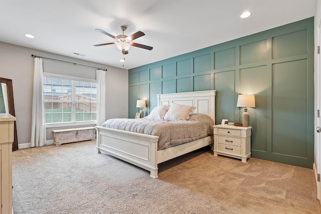 bedroom featuring visible vents, light colored carpet, ceiling fan, a decorative wall, and recessed lighting