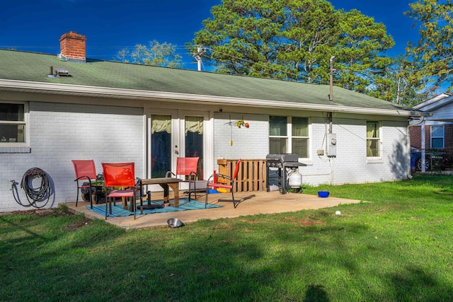 back of property with a patio and a lawn