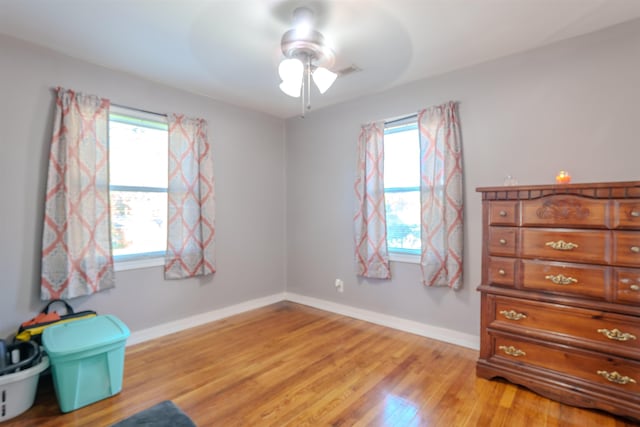 bedroom featuring multiple windows, ceiling fan, and light wood-type flooring