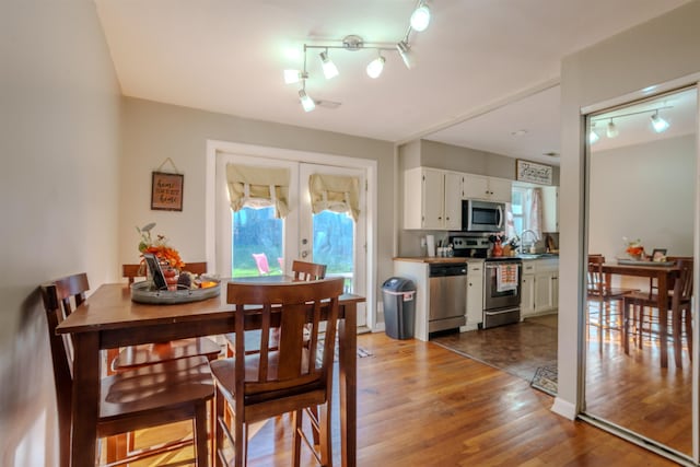 dining area featuring french doors, dark hardwood / wood-style floors, and sink