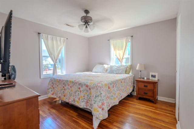 bedroom featuring multiple windows, ceiling fan, and hardwood / wood-style floors