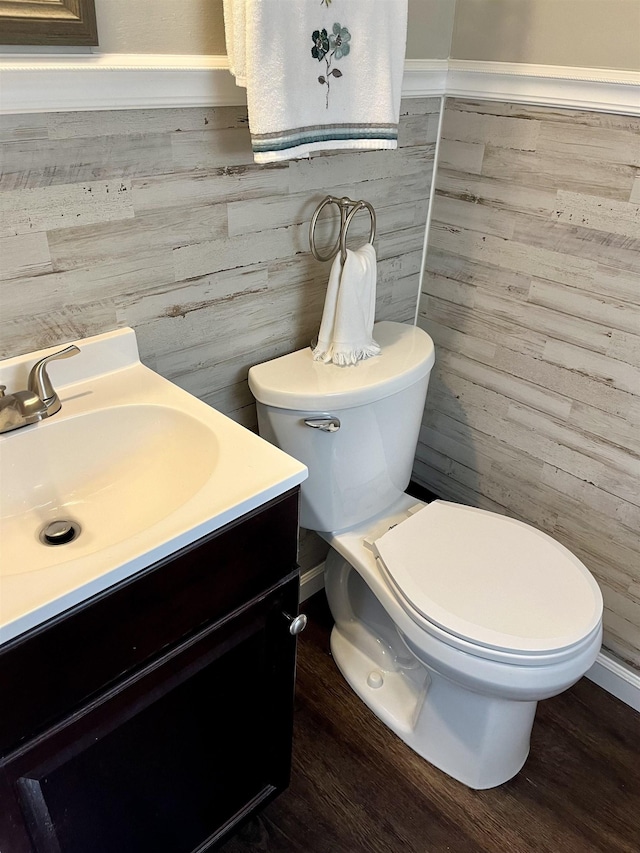 bathroom with hardwood / wood-style floors, vanity, and toilet