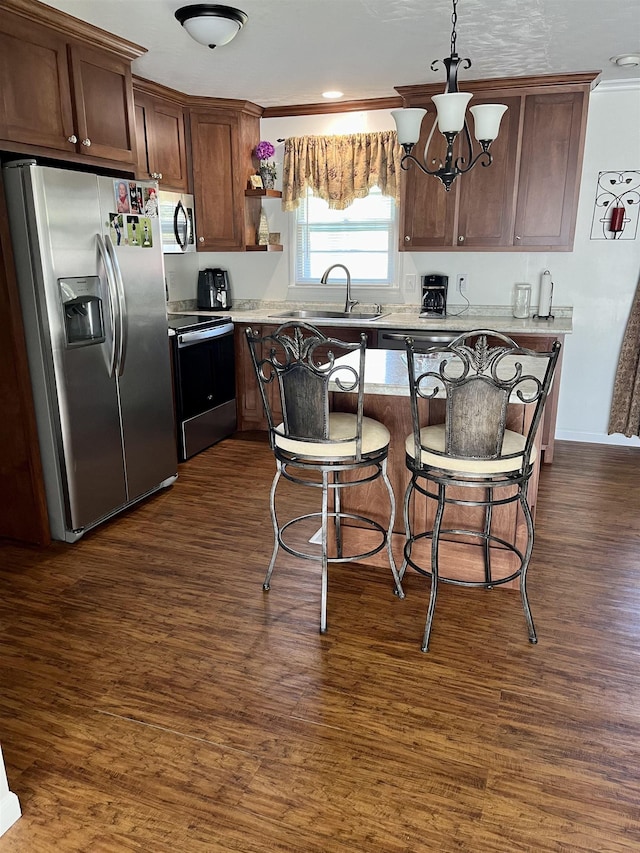 kitchen with an inviting chandelier, hanging light fixtures, sink, dark hardwood / wood-style floors, and appliances with stainless steel finishes