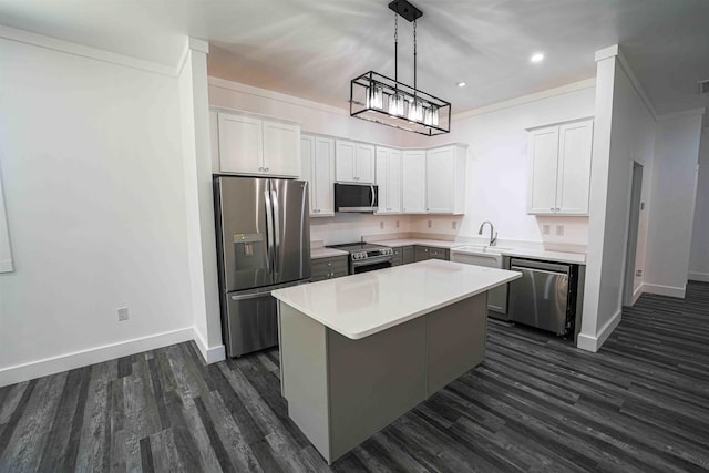 kitchen featuring a kitchen island, appliances with stainless steel finishes, ornamental molding, dark wood-style flooring, and light countertops