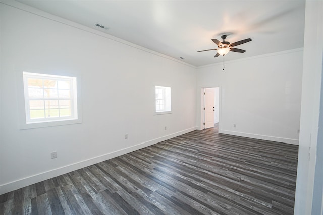 empty room with ornamental molding, dark wood finished floors, baseboards, and a ceiling fan