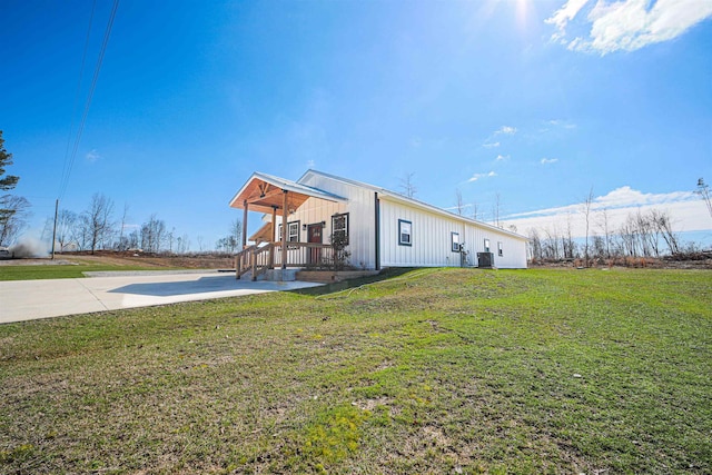 back of house featuring central AC unit and a lawn