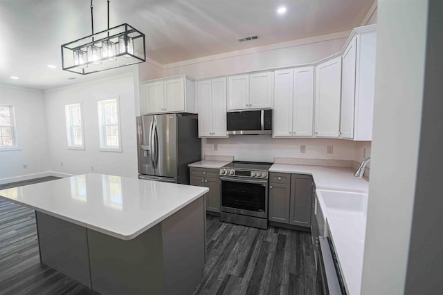 kitchen featuring dark wood-style floors, light countertops, visible vents, appliances with stainless steel finishes, and a kitchen island