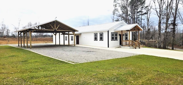 exterior space featuring gravel driveway, metal roof, and a front lawn