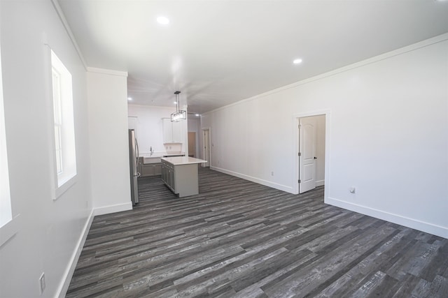 unfurnished living room with dark wood-style floors, baseboards, crown molding, and recessed lighting