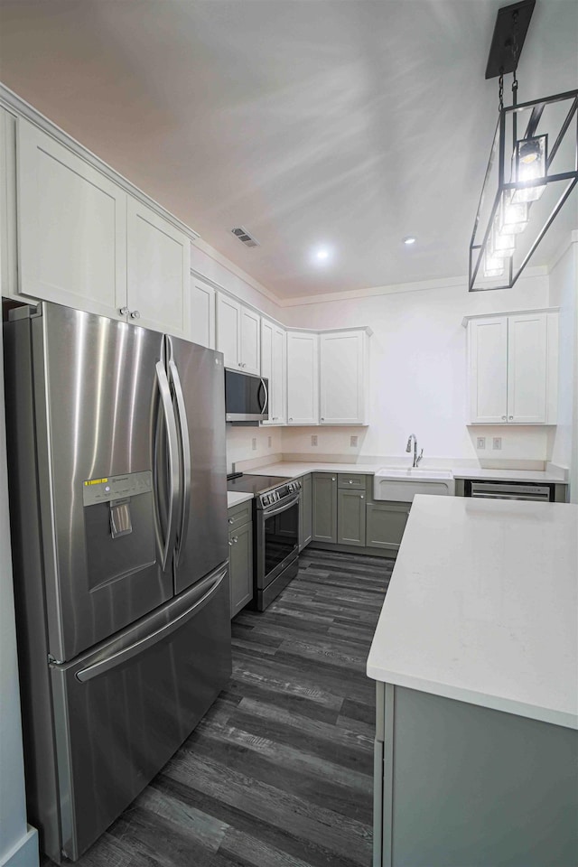 kitchen featuring a sink, visible vents, light countertops, appliances with stainless steel finishes, and dark wood-style floors