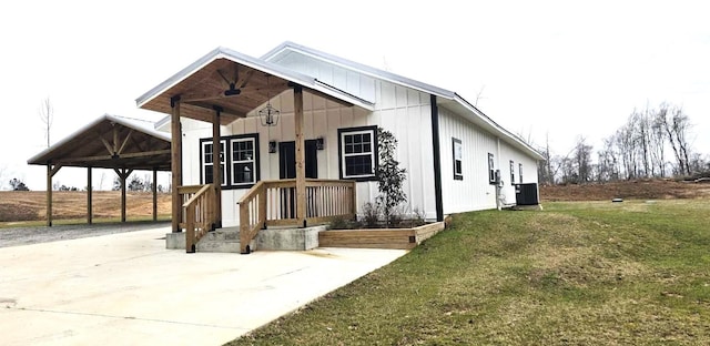 modern farmhouse featuring an attached carport, central AC, driveway, a front lawn, and board and batten siding