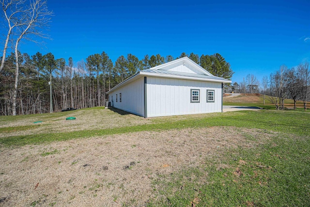 view of property exterior featuring metal roof, a yard, and a standing seam roof