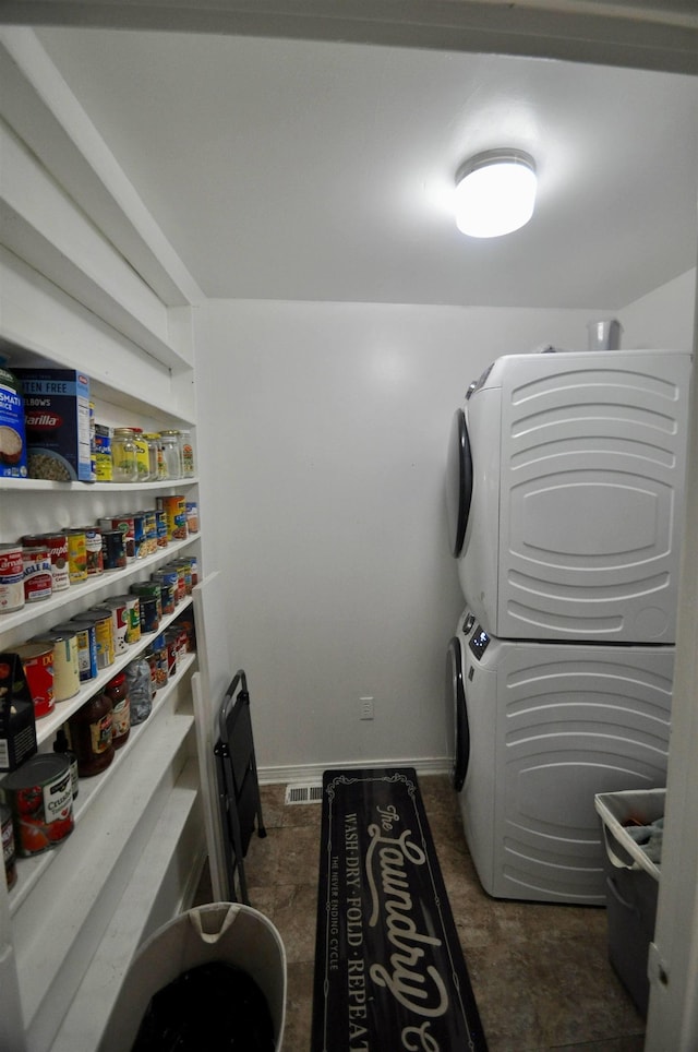  - laundry room featuring estacked washer and dryer and baseboards