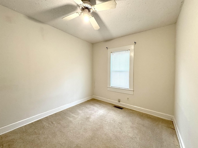 spare room with ceiling fan, a textured ceiling, and carpet