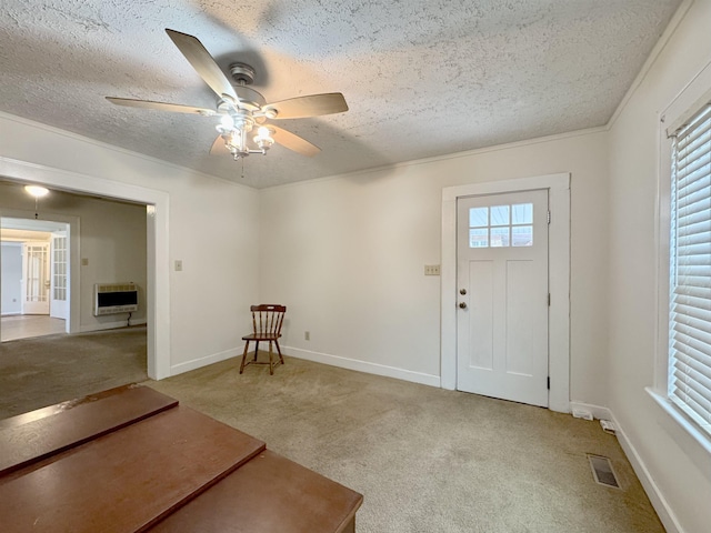 carpeted entryway with heating unit, ceiling fan, a wealth of natural light, and a textured ceiling