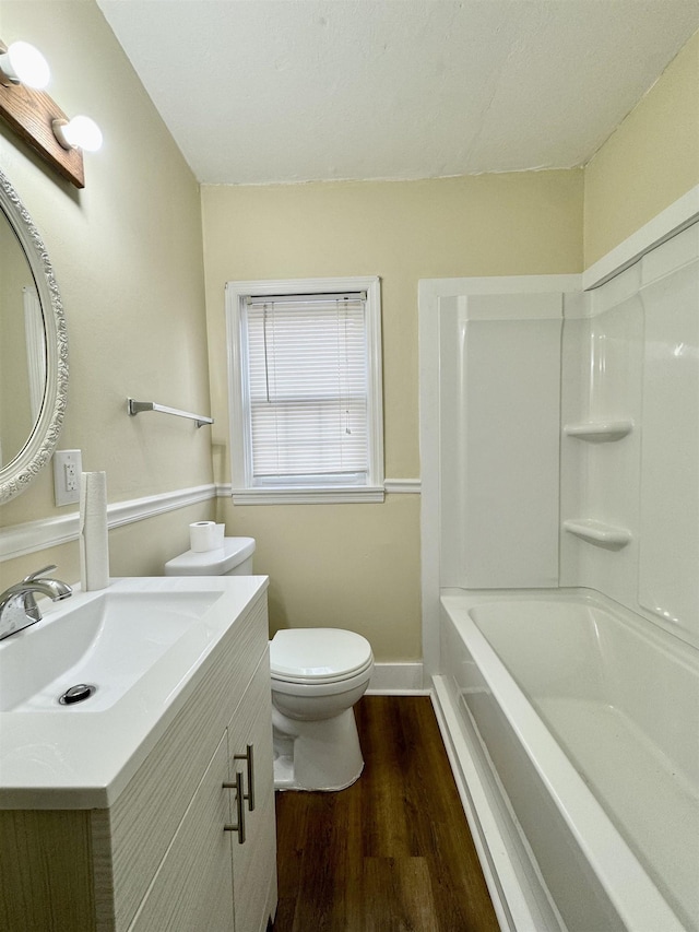 full bathroom featuring hardwood / wood-style flooring, vanity, shower / bath combination, and toilet