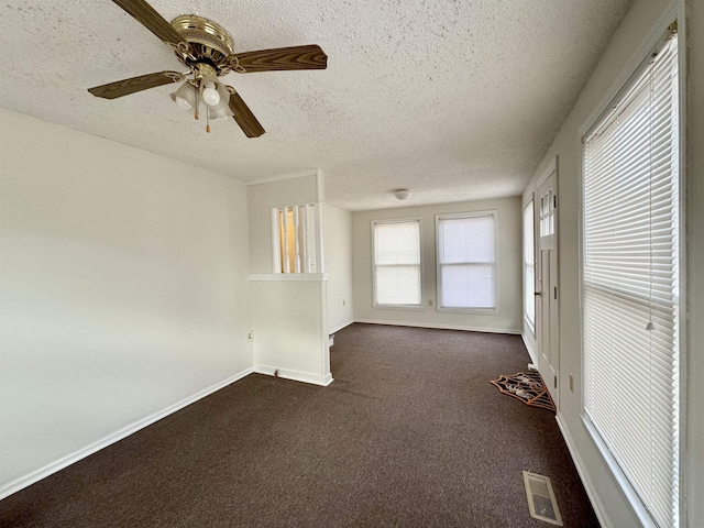 carpeted empty room featuring ceiling fan and a textured ceiling