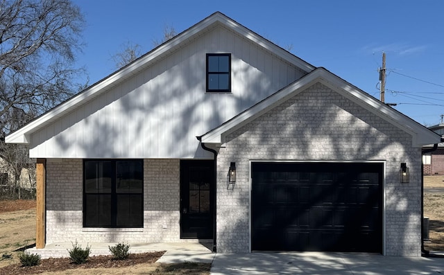 view of front facade featuring a garage, driveway, and brick siding