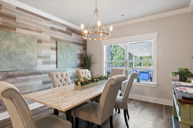 dining room with ornamental molding, dark hardwood / wood-style flooring, an inviting chandelier, and wooden walls