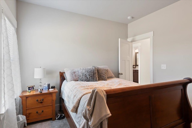 bedroom with light colored carpet and ensuite bath