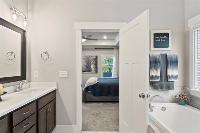 bathroom with vanity, ceiling fan, and a relaxing tiled tub