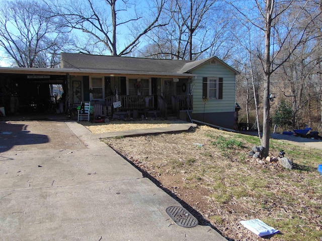 ranch-style house featuring covered porch and a carport