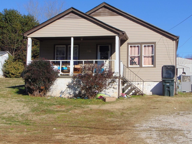 bungalow-style home featuring covered porch and a front yard